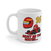 White ceramic mug with cartoon red F1 car, number 16, racing helmet, and text “Must Be the Water…” – inspired by Charles Leclerc and Ferrari Formula 1.