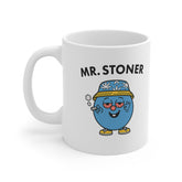 White ceramic mug with cartoon stoner character wearing a leaf-patterned bucket hat, holding a joint and flashing peace signs. Text reads “Mr. Stoner.”