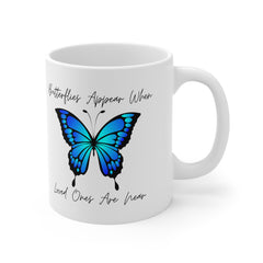 White ceramic mug featuring a blue butterfly and the quote “Butterflies appear when loved ones are near” – a sentimental memorial or sympathy gift.