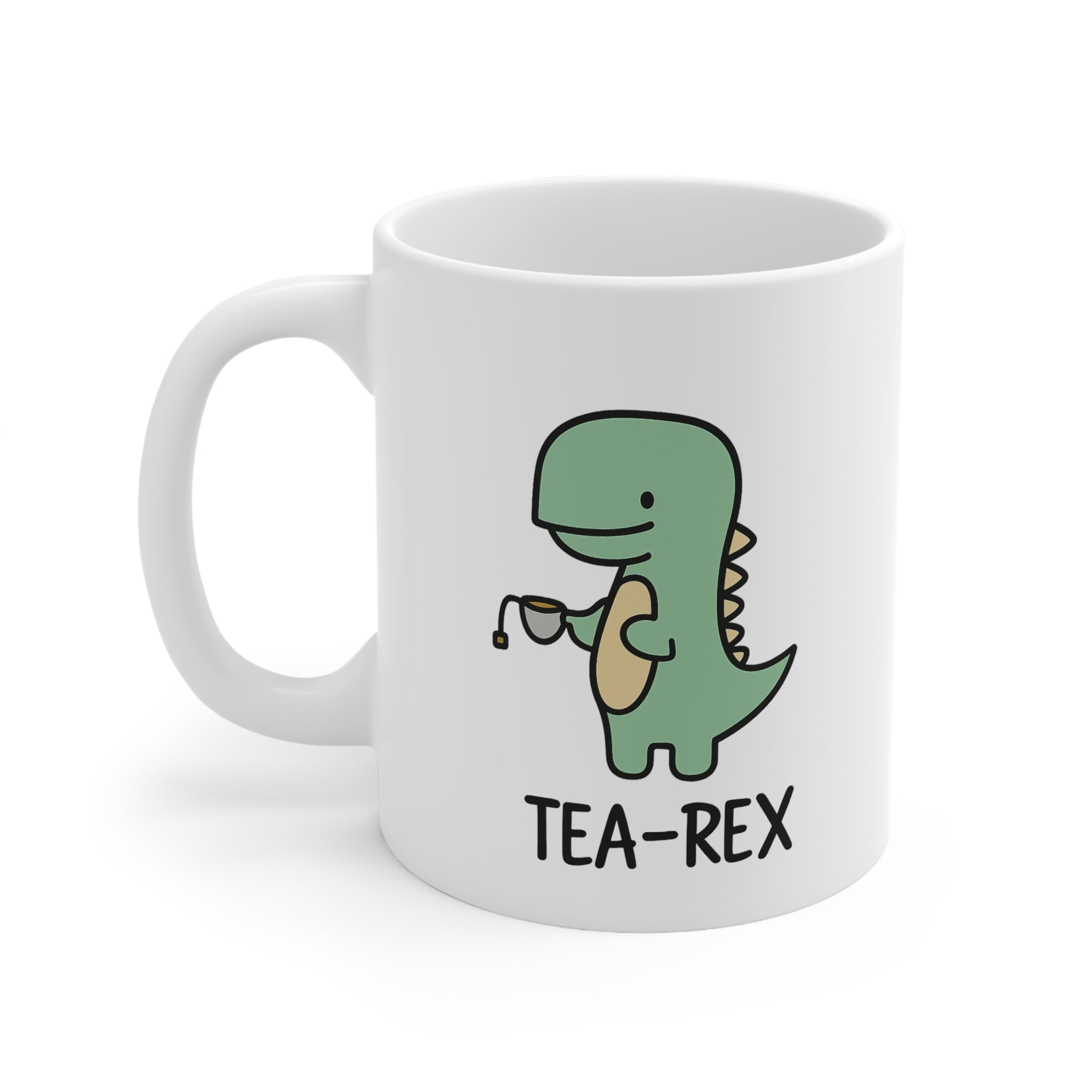 White ceramic mug with a cute green cartoon dinosaur holding a teacup and the caption “Tea-Rex” – a funny pun mug for tea and dino lovers.