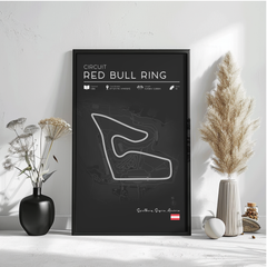 a poster of the Circuit Red Bull Ring, a racing circuit in Spain, with a black background and white text. The poster is displayed on a wall, accompanied by decorative elements such as a vase with flowers and a potted plant.