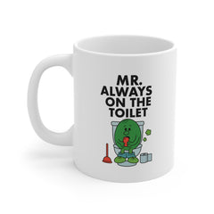 White ceramic mug with a cartoon green character sitting on a toilet, holding a phone, and the text “Mr. Always On The Toilet” – funny novelty gift.