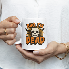 Person holding a mug with a skull design and text.