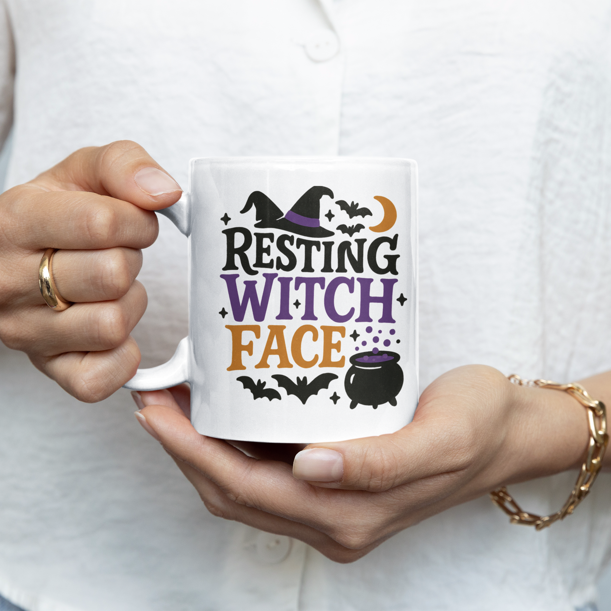 Person holding a mug with 'Resting Witch Face' design