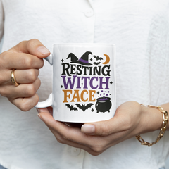 Person holding a mug with 'Resting Witch Face' design
