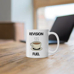 White ceramic mug with a cartoon coffee cup and the text “Revision Fuel” – funny motivational mug for students during exams or study sessions.